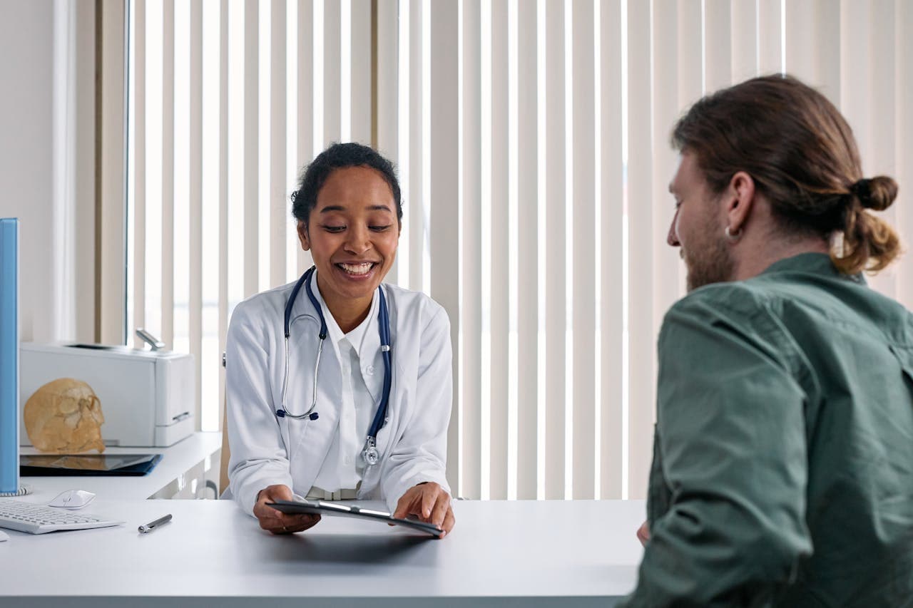 Doctor consulting with patient using digital tablet